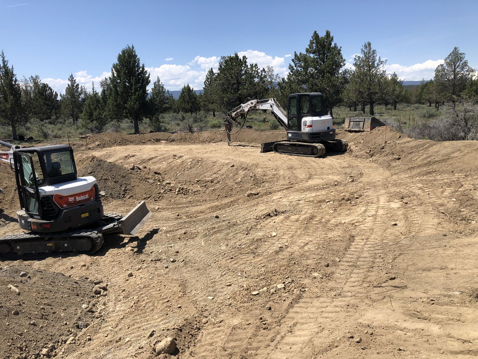 Excavator digging into asphalt, revealing a deep trench