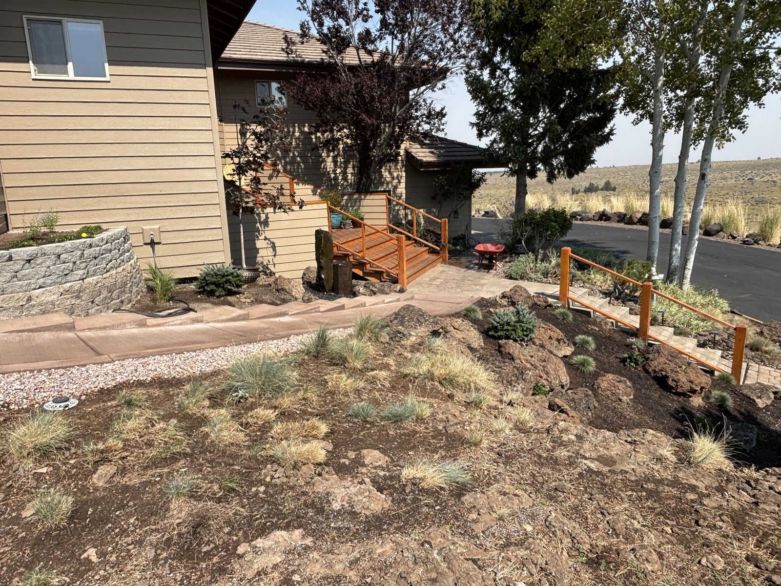 A landscaped pathway leads to a home, featuring a wooden deck