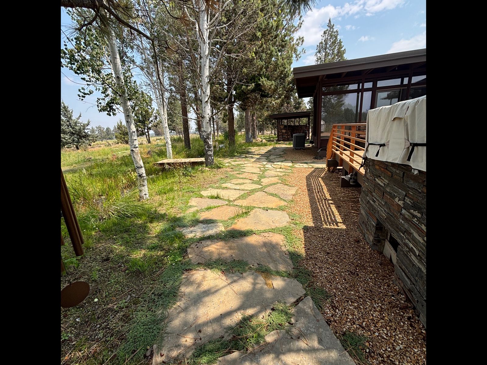 Custom flagstone pathway and gravel bed alongside a modern Central Oregon home